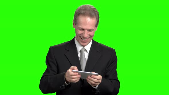 Mature Businessman Playing Video Games on Smartphone.