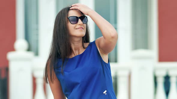 Portrait of Smiling European Woman in Sunglasses on Terrace or Balcony
