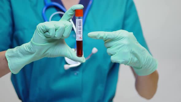 Medical Doctor Nurse Woman Wearing Protective Mask and Gloves - Holding COVID-19 Positive Blood Test