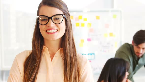 Smiling executive standing with arms crossed