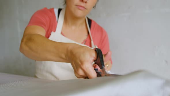 Woman cutting fabric for surfboard