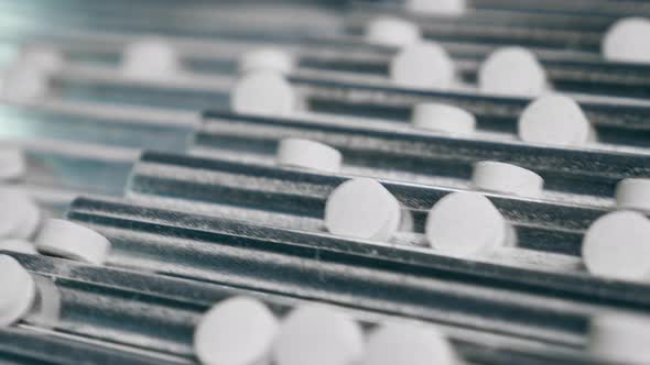 Close Up of White Tablets Getting Transported By a Conveyor