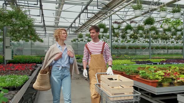 Blonde Woman Housewife Buys a Plant in the Nursery and Talks to the Gardener