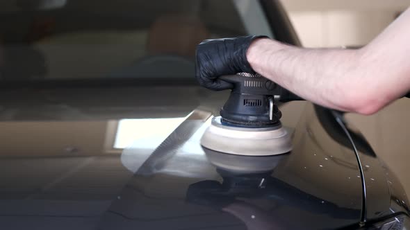 Man Polish a Car in a Garage