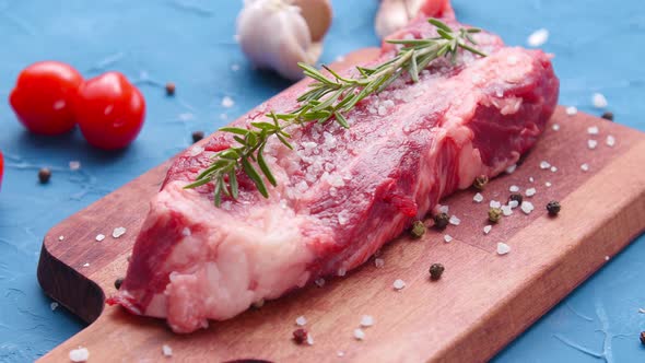 Raw Fresh Meat Steak with Herbs and Spices on Rustic Background