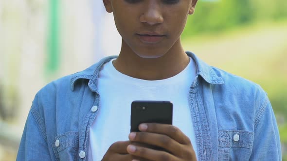 Extremely glad African-American boy with smartphone