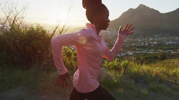 African american woman exercising outdoors running in country side during sunset