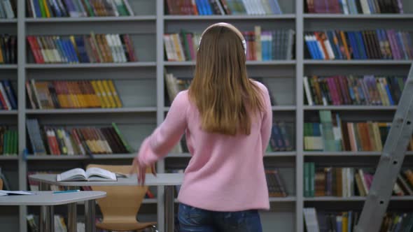 Young Woman in Headphones Dancing Back To Camera