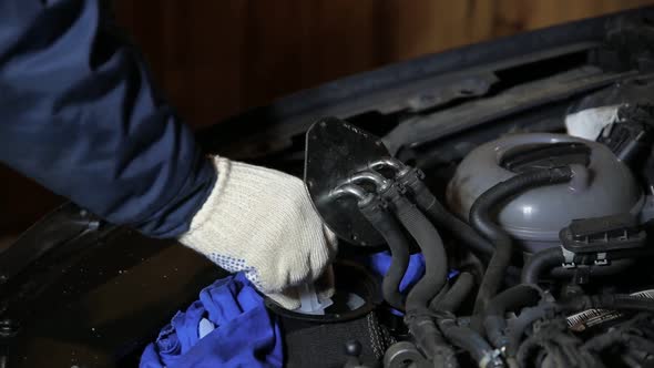 Automotive Mechanic Removes Old Fuel Residue From Under the Fuel Filter