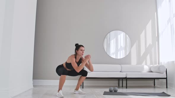 Woman Exercising Jumping Squats in Home