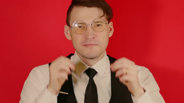 Young Man in Business Suit Puts on Glasses