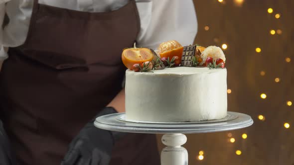 Closeup of a Chief's Hand Decorating the Chocolate Cake with Cheese Souffle