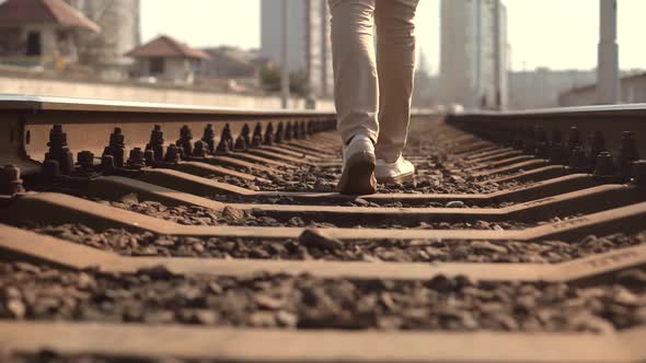 Man Walks To Home On Railroad Tracks. Legs Walking On Rail Road.Walking On Railway Middle Of Rail