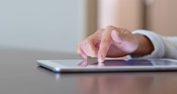 Woman finger touch on tablet computer at home