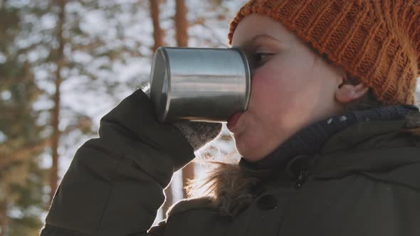 Little Girl Drinking Hot Tea on Hike in Winter