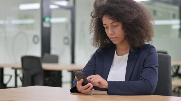 Serious Young African Businesswoman Using Smartphone 