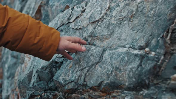 Man Sliding Hand Against Old Ancient Stone Wall in Slow Motion