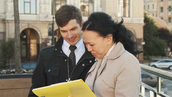 The Pleasant Man and Woman Discuss Some Documents and Smile