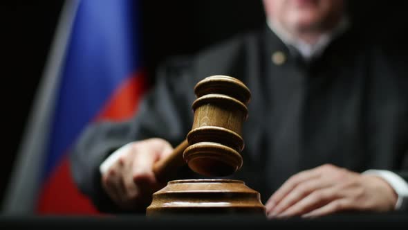 Judge With Hammer In His Hand Against Russian Flag In Court Room