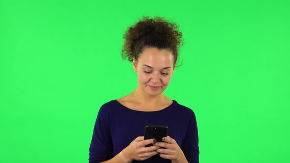 Portrait of Curly Woman Smiling Woman Texting on Her Phone, Green Screen