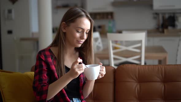 Beautiful young woman eats bowl of healthy granola