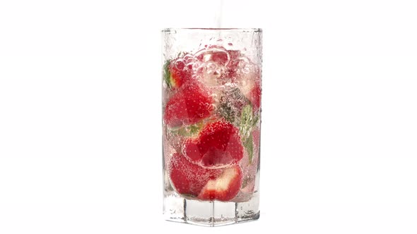 Pouring Fresh Cold Mineral Water Into Glass with Ripe Strawberry Mint Summer Delicious Cocktail