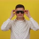 Young 20s Guy Posing and Smiling on a Yellow Background in a White Shirt and Funny Glasses - VideoHive Item for Sale