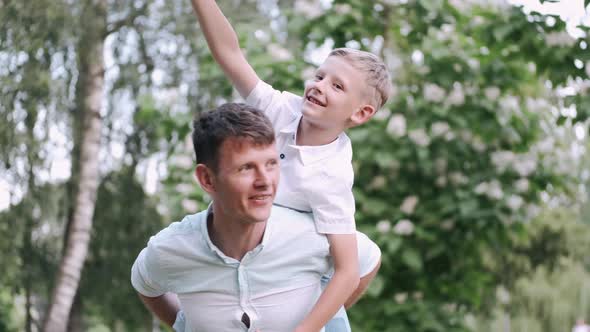 Happy Father with a Little Son at the Back in the Park