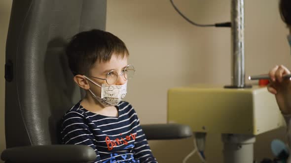 Optometrist Uses Led Torch To Check Kid's Vision. Hello in French on Sweater