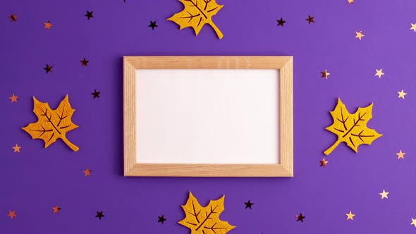 Stop motion animation of yellow felt autumn leaves star shapes and wooden picture frame on purple