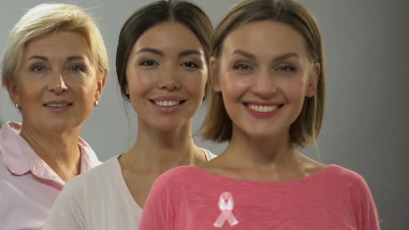 Women of Different Age With Pink Ribbon Smiling at Camera, Breast Cancer Control