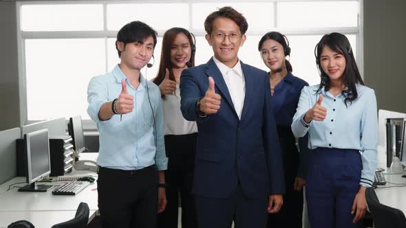 Business team showing thumbs up sign gesture and looking at camera