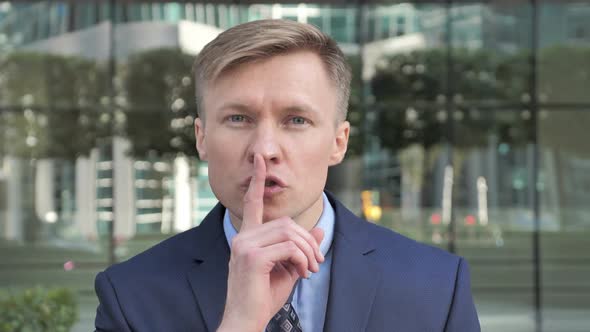 Silence Please Finger on Lips By Businessman