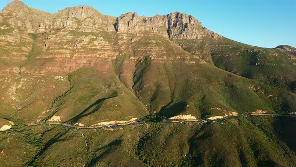 parallel aerial of Chapmans Peak coastal mountain road in Cape Town at sunset