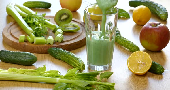 Pouring Organic Freshly Squeezed Green Vegetable and Fruit Smoothie Into the Glass