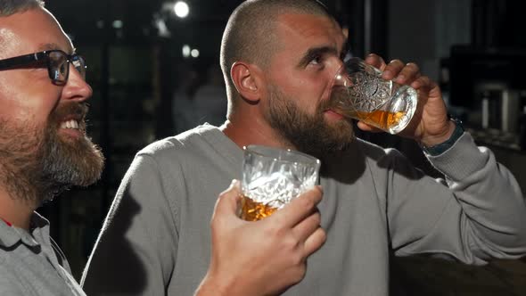 Handsome Man and His Friend Watching Football Game at Whiskey Bar