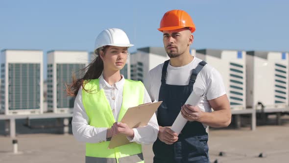 Two Happy Engineers are Standing and Watching the Camera