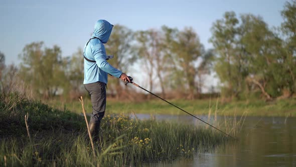 The Fisherman Sportsman Catches a Predatory Fish on a Spinning on the Lake