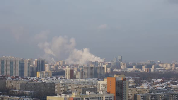 City Pipes Emit Steam Into the Atmosphere Against the City Skyline