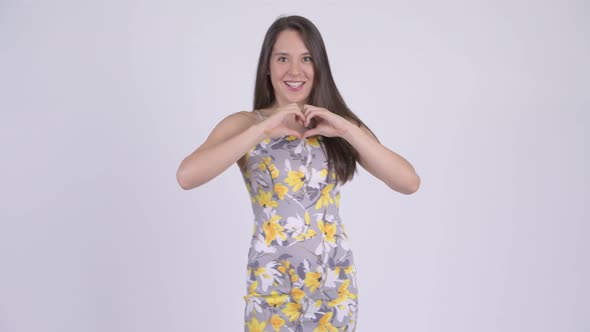 Young Happy Multi-ethnic Tourist Woman with Hand Heart Gesture