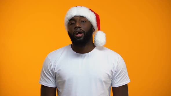 Seductive Afro-American Santa Man Sending Air Kiss and Winking, Carnival Party