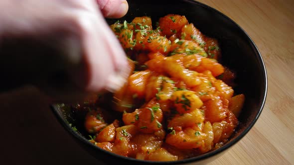 Mixing Chicken Breast In A Bowl, Seasoned With Spices And Chopped Parsley. close up