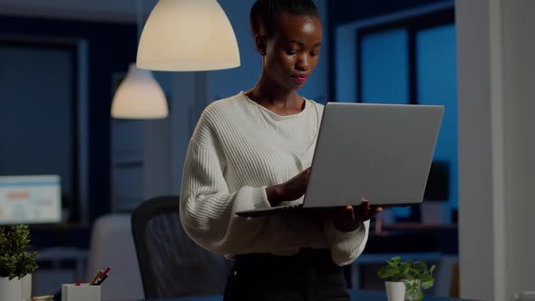 Black Business Woman Looking at Camera Smiling Holding Laptop