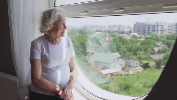 Senior Woman Sitting on Windowsill