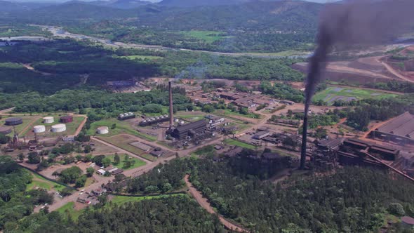 Aerial view of dark smoke rising from Mine and plant chimneys, polluting the nature - orbit, drone s