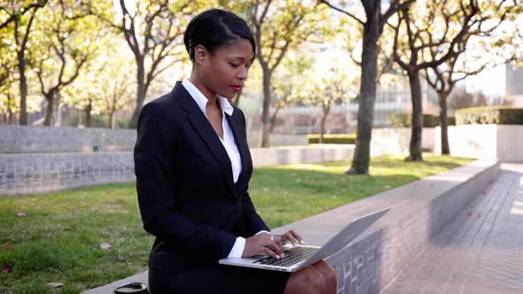 Mixed ethnicity business woman works on her laptop