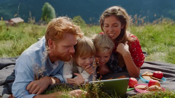 Family Looking Tablet Screen Lying Green Meadow Close Up