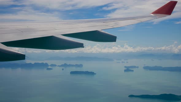 View From The Window Of An Airplane Flying Over The Sea With Tropical Islands