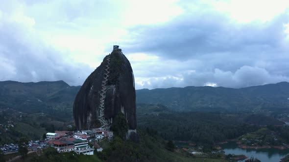 Aerial rising up in front of La pietra, Guatape during evening. Drone 4k.