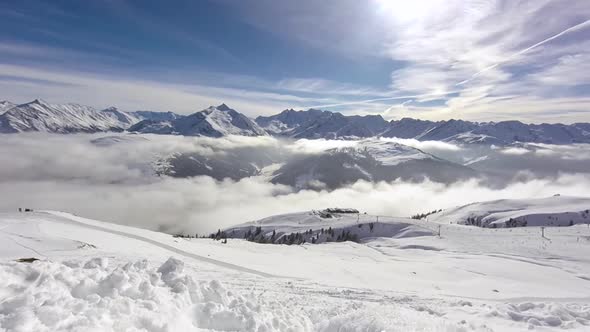Time lapse of fog traveling through snowy mountain peaks